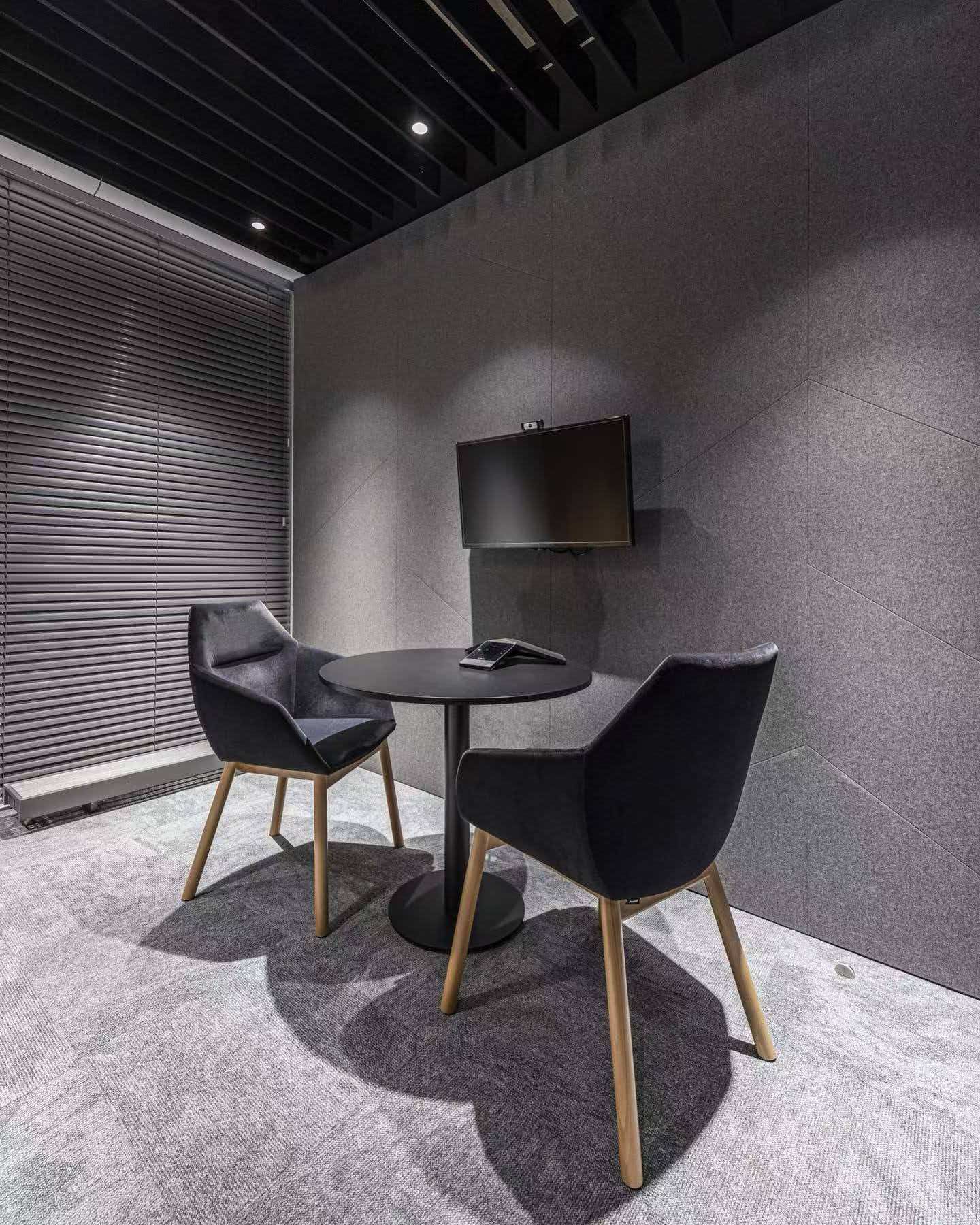 Dark meeting room with grey geometric felt wall treatment