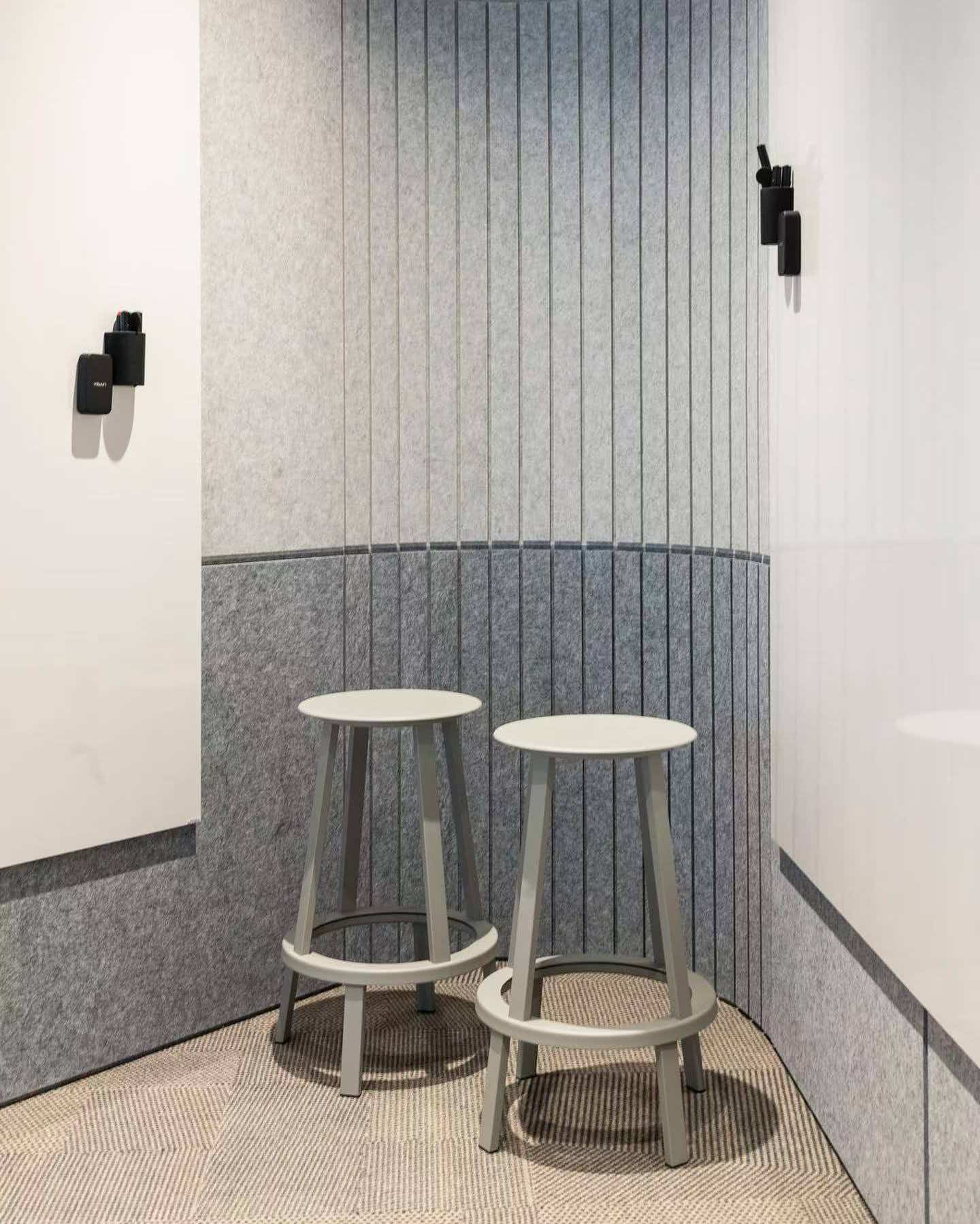 Small collaboration space with two-tone vertically grooved felt wall treatment