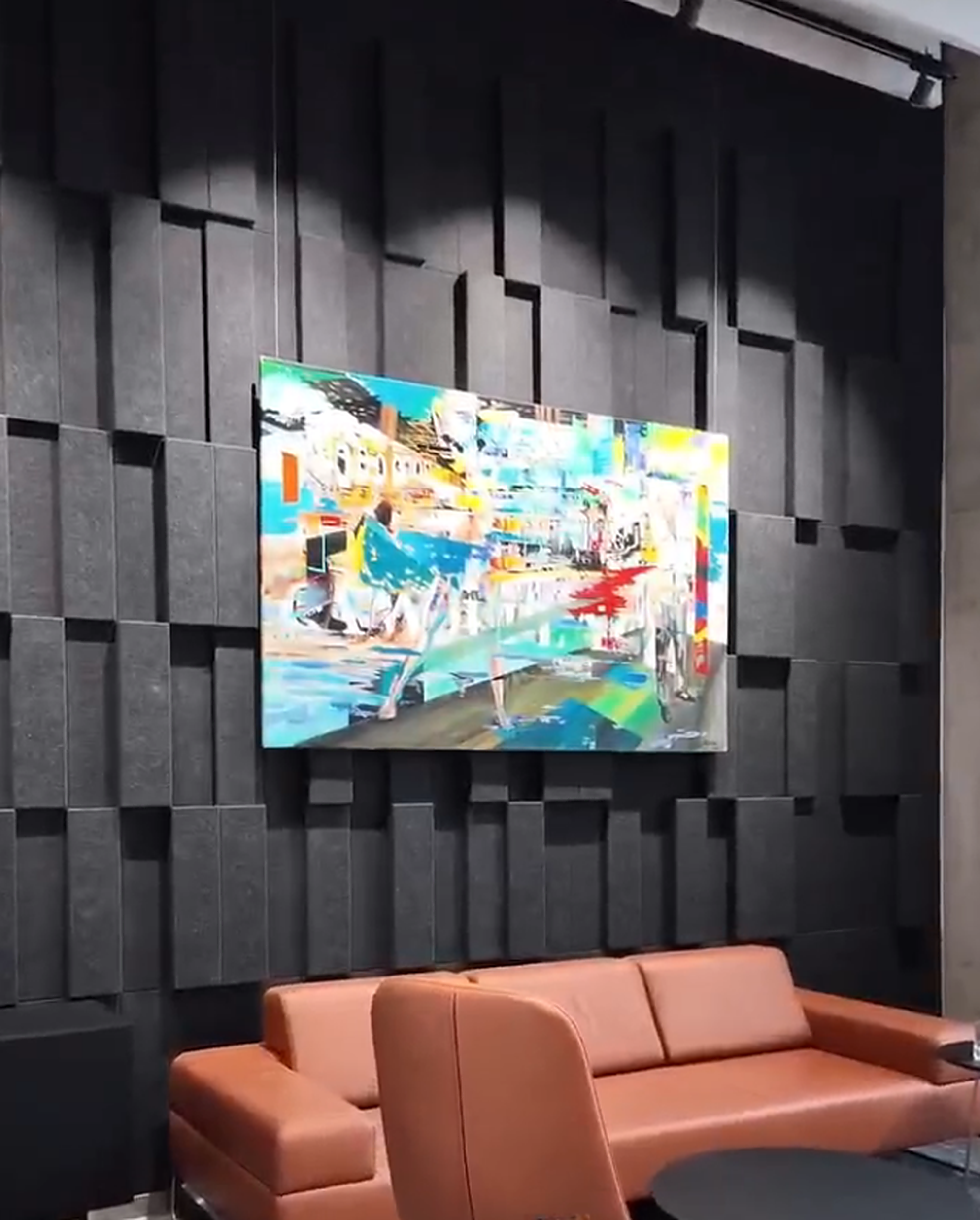 Residential lounge with black layered geometric wall treatment behind a television