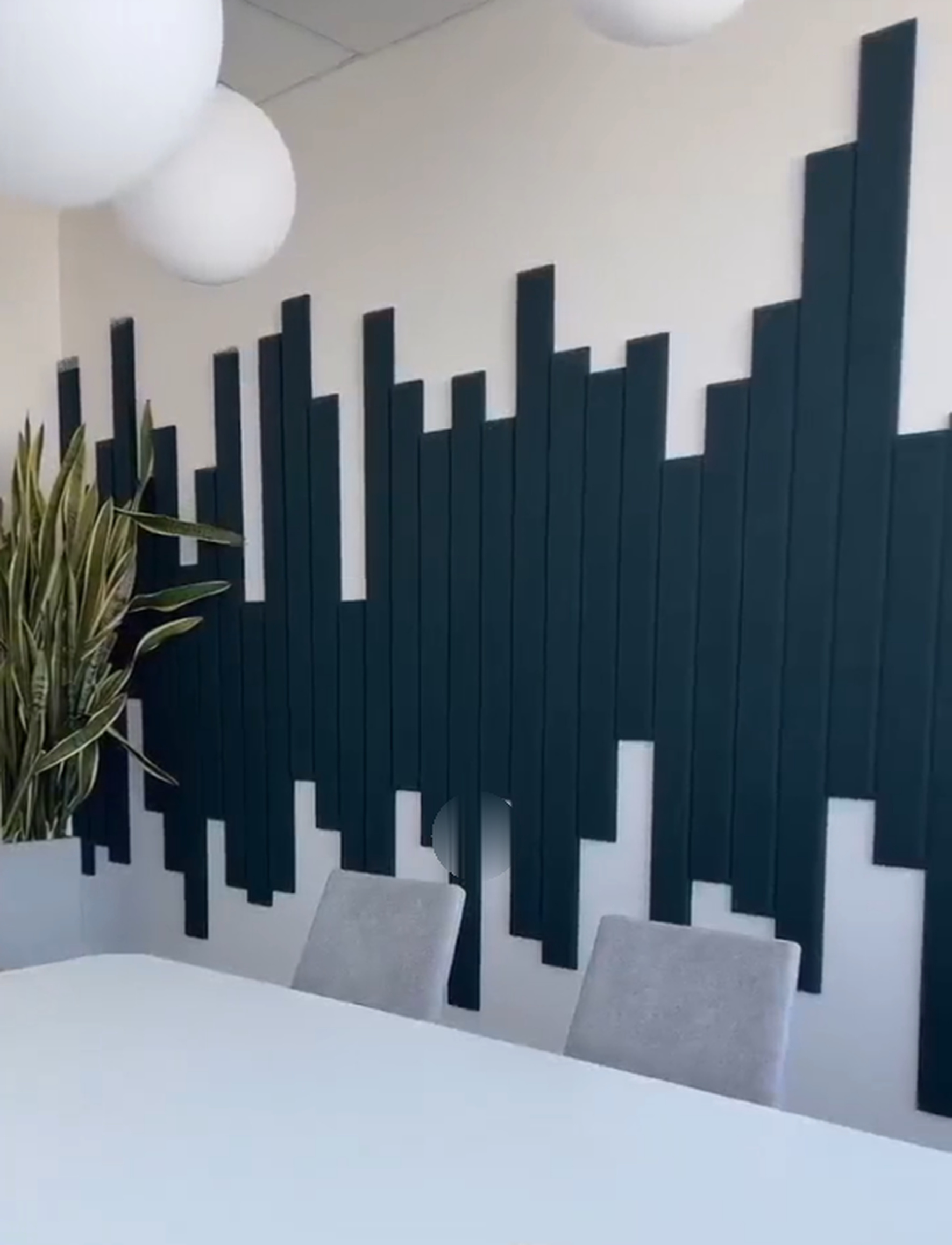 Workspace meeting area with staggered dark vertical wall strips