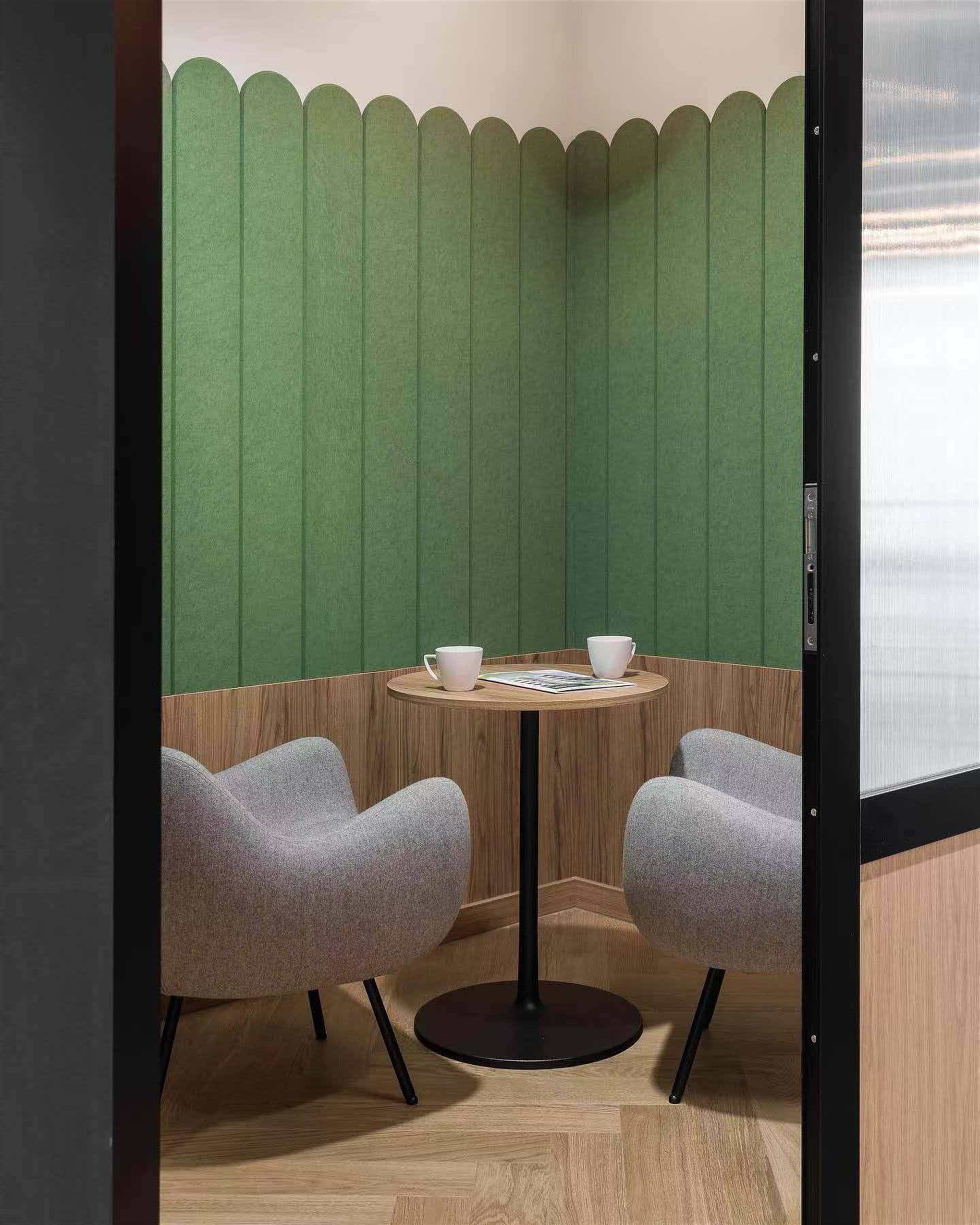 Workspace booth with green scalloped vertical wall panels